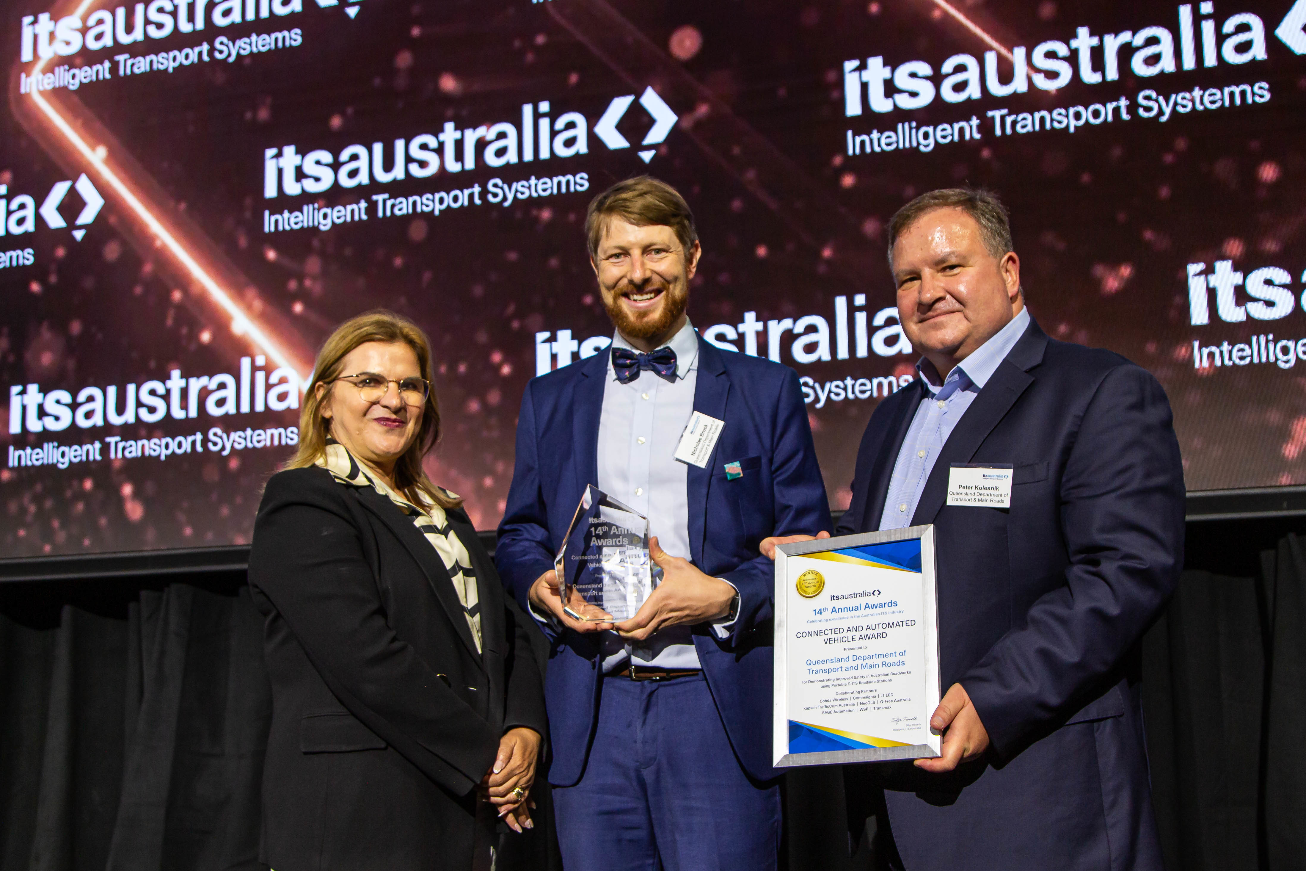 Nicholas Brook and Peter Kolesnik from Qld Department of Transport and Main Roads accepting the Connected and Automated Vehicle Award from Rita Excel, AWS and ITS Australia Board Member